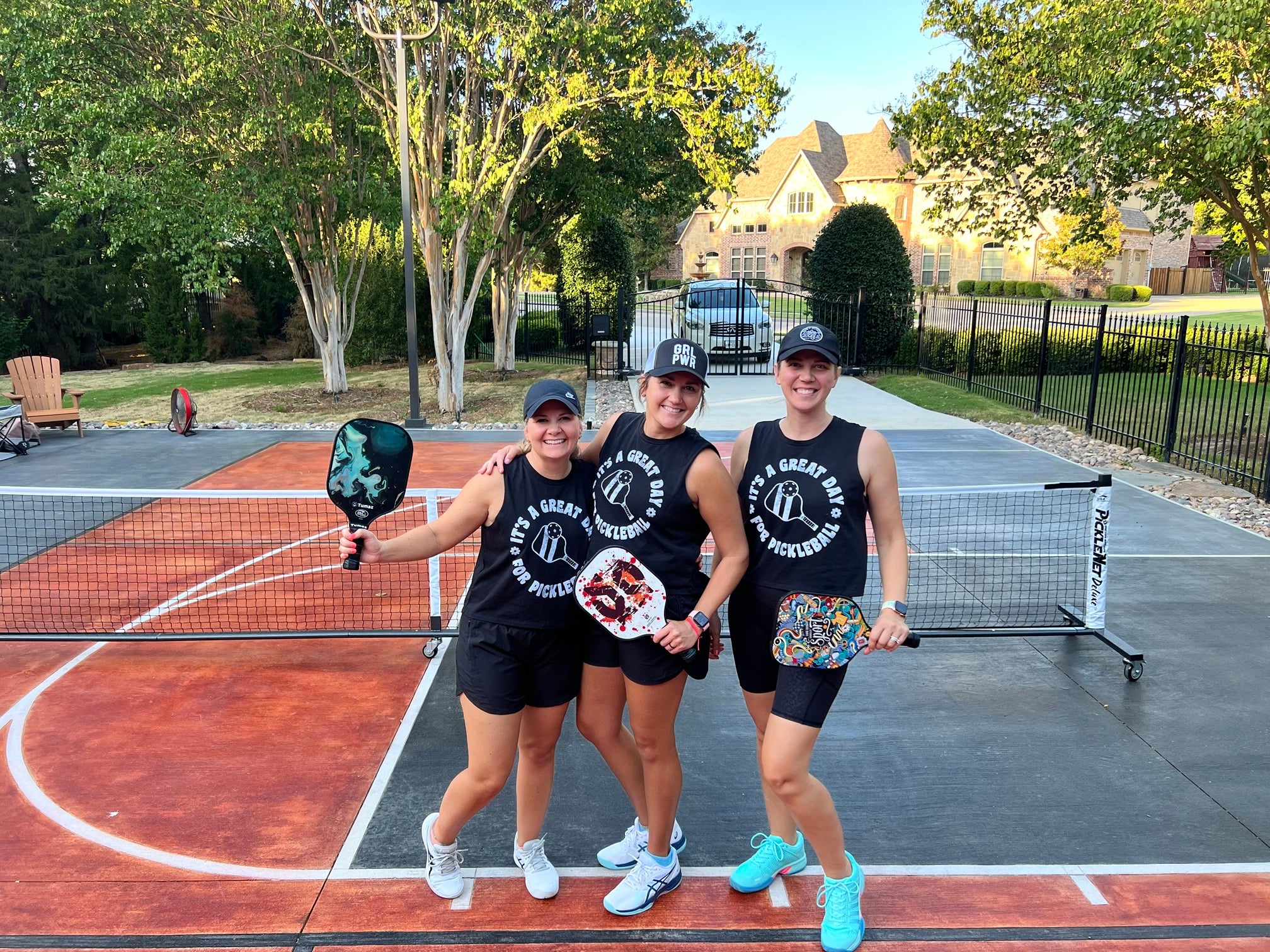 Three girls wearing matching pickleball gear about to play pickleball